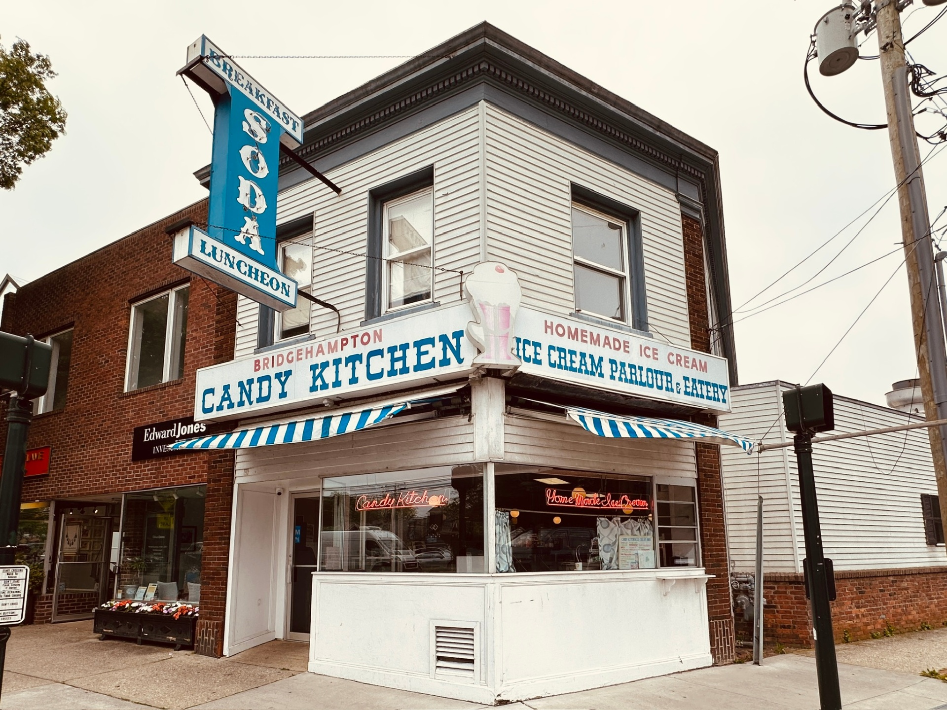 Candy Kitchen's Bridgehampton corner storefront with the blue SODA LUNCHEON sign and striped awnings